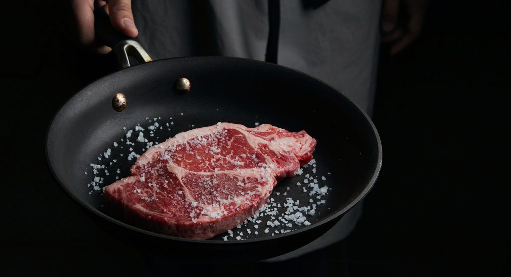 Steak cooking in frying pan